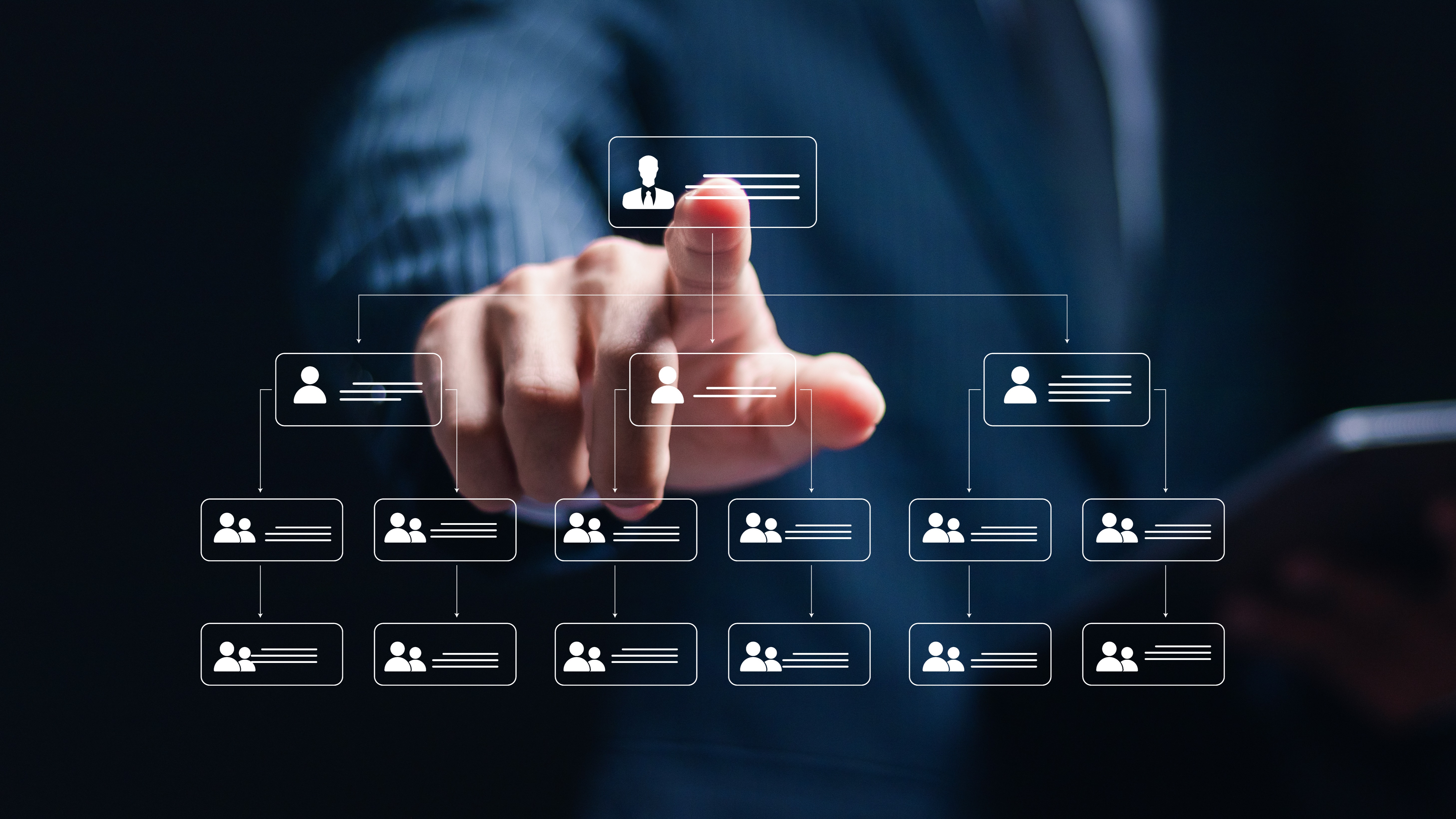 A suited businessman points at a glowing digital organizational chart hierarchy displayed against a dark blue background.
