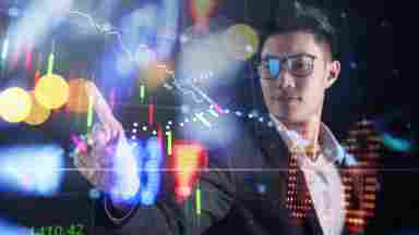 Businessman pointing at financial data on a transparent LED screen.