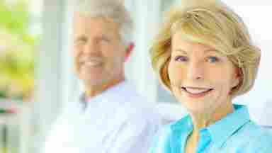 Happy elderly couple smiling, looking at the camera. Older. White.