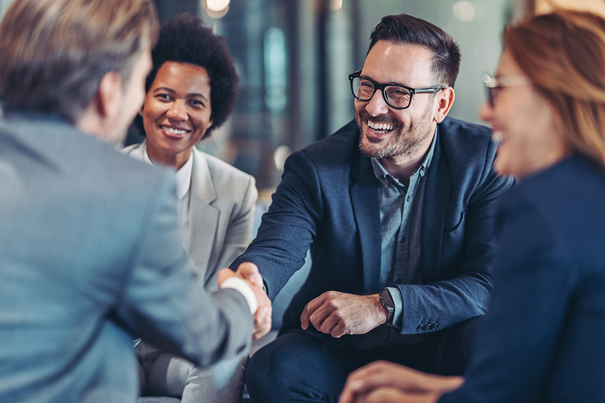 Diverse business people shaking hands and smiling.