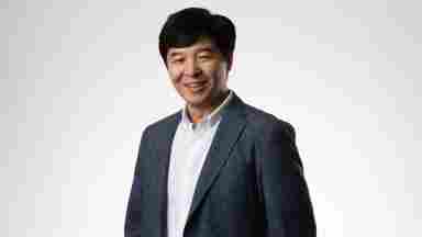 Yune S. Lee is wearing a dark blue blazer with lights, landscape. Close-up.