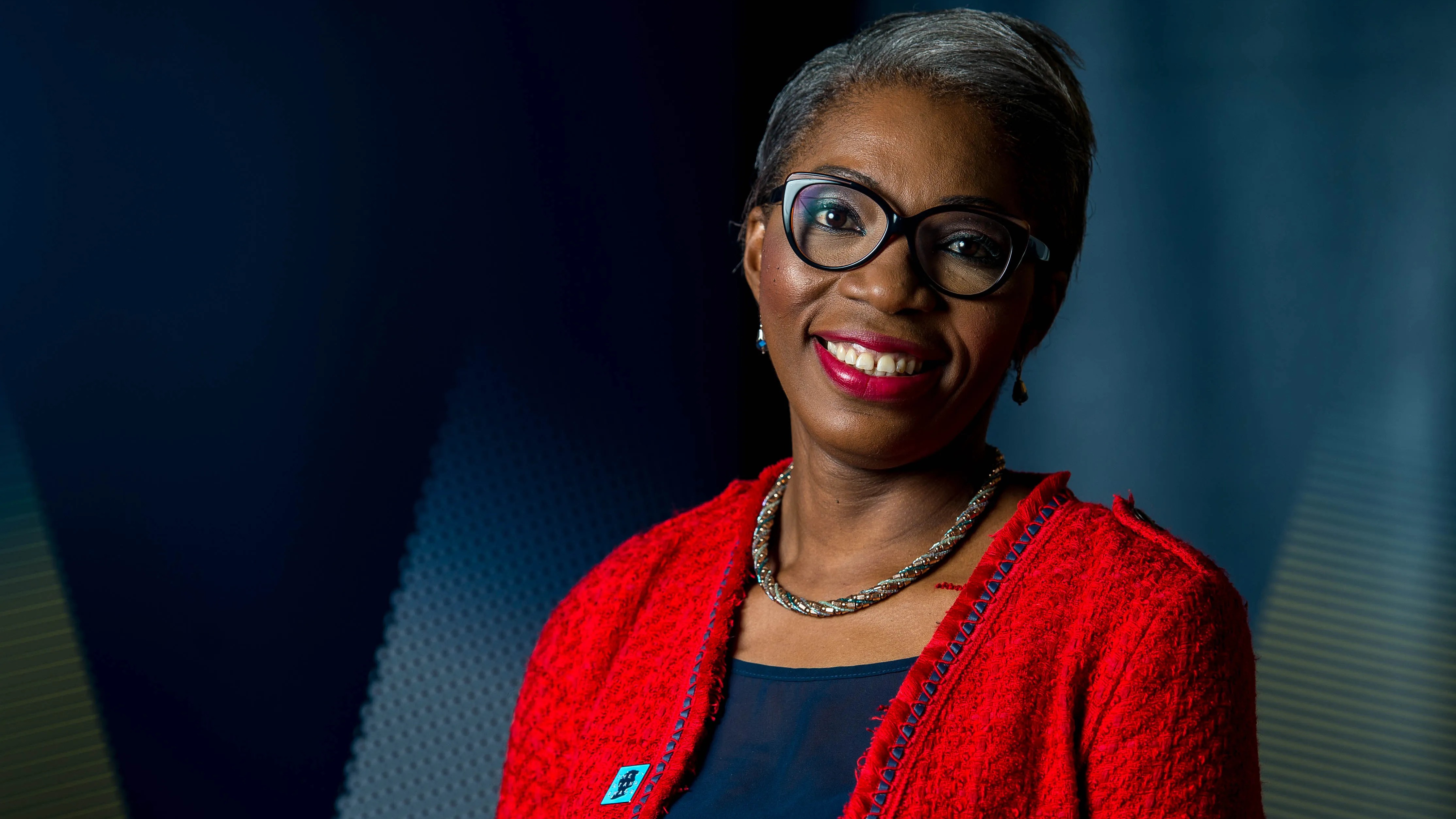 Portrait of Tessy Ojo in a red blazer.