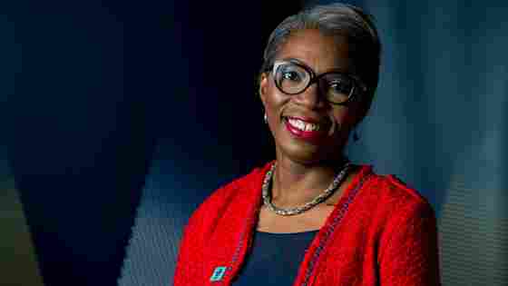 Portrait of Tessy Ojo in a red blazer.