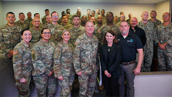 Center for BrainHealth's Jennifer Zientz and Thad King stand with service members participating in Optimal BrainHealth for Warfighters, following a SMART seminar with the Joint Communications Support Element (JCSE) at , FL. The JCSE is a joint command (Army, Navy, Airforce and Marines).