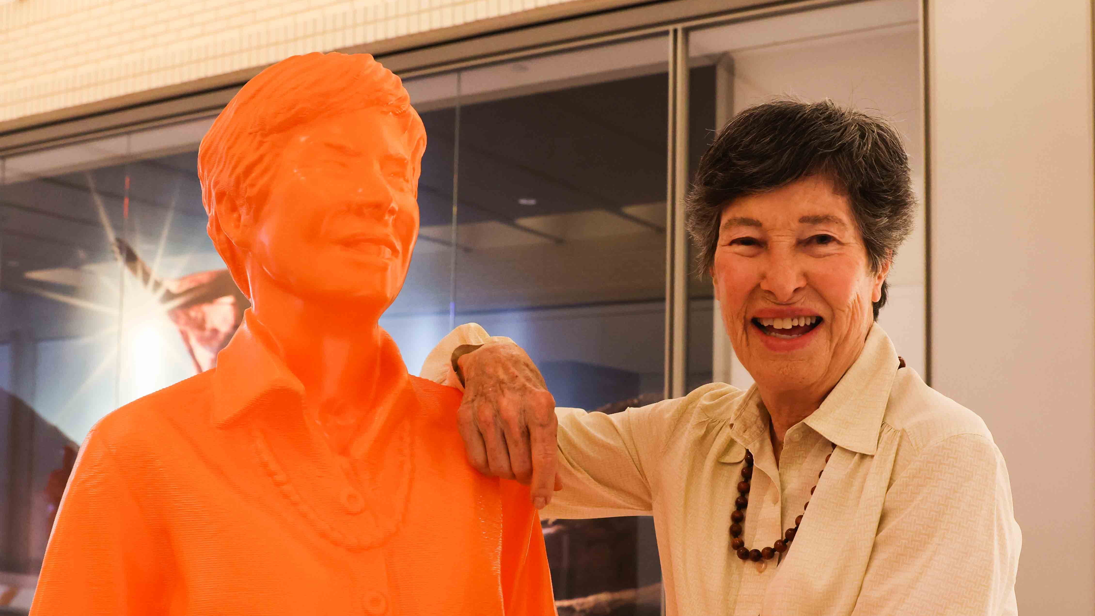 Lyda Hill with an orange statue of herself. 