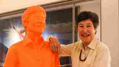 Lyda Hill with an orange statue of herself. 