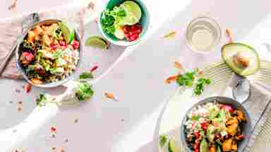 A plain white table matt with multiple salad bowls. 