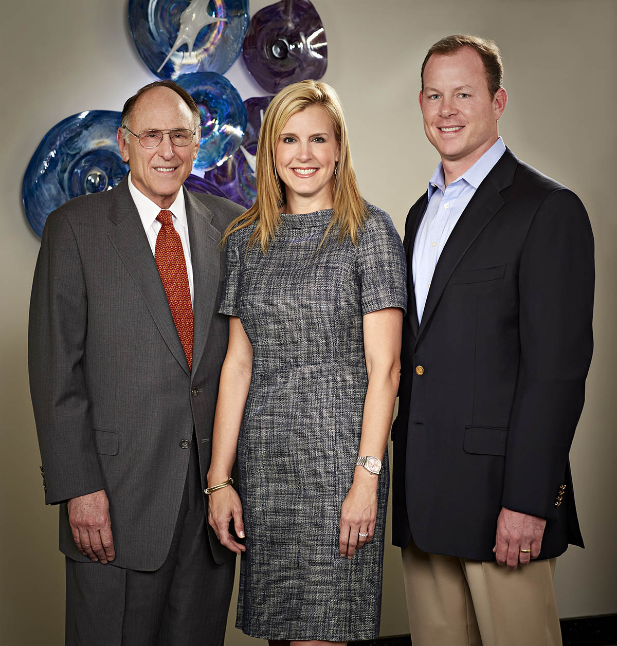 Three RGK Foundation members shown standing side by side. This includes Gregory A. Kozmetsky, Chairman of RGK Foundation, plus Aaron and Tracey Kozmetsky.