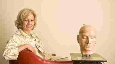 Dr. Sandra Chapman sitting on a red chair