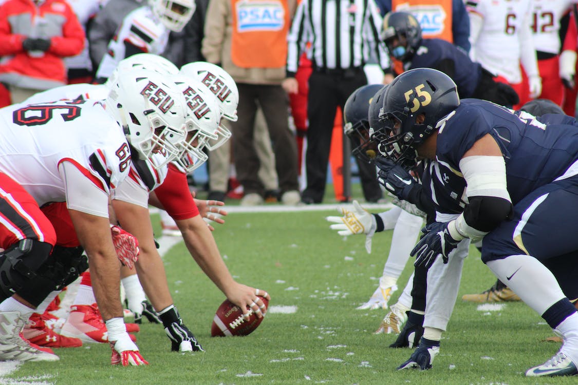 Men in white facing off with men in blue