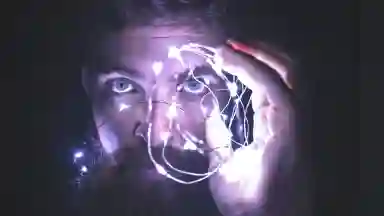 A close up picture of a man looking through lights