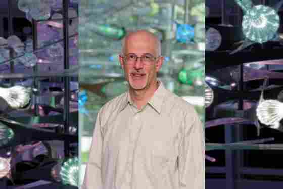 Jeremy Gray, PhD Hero with colorful glass sculpture background. Director of Information Technology. 