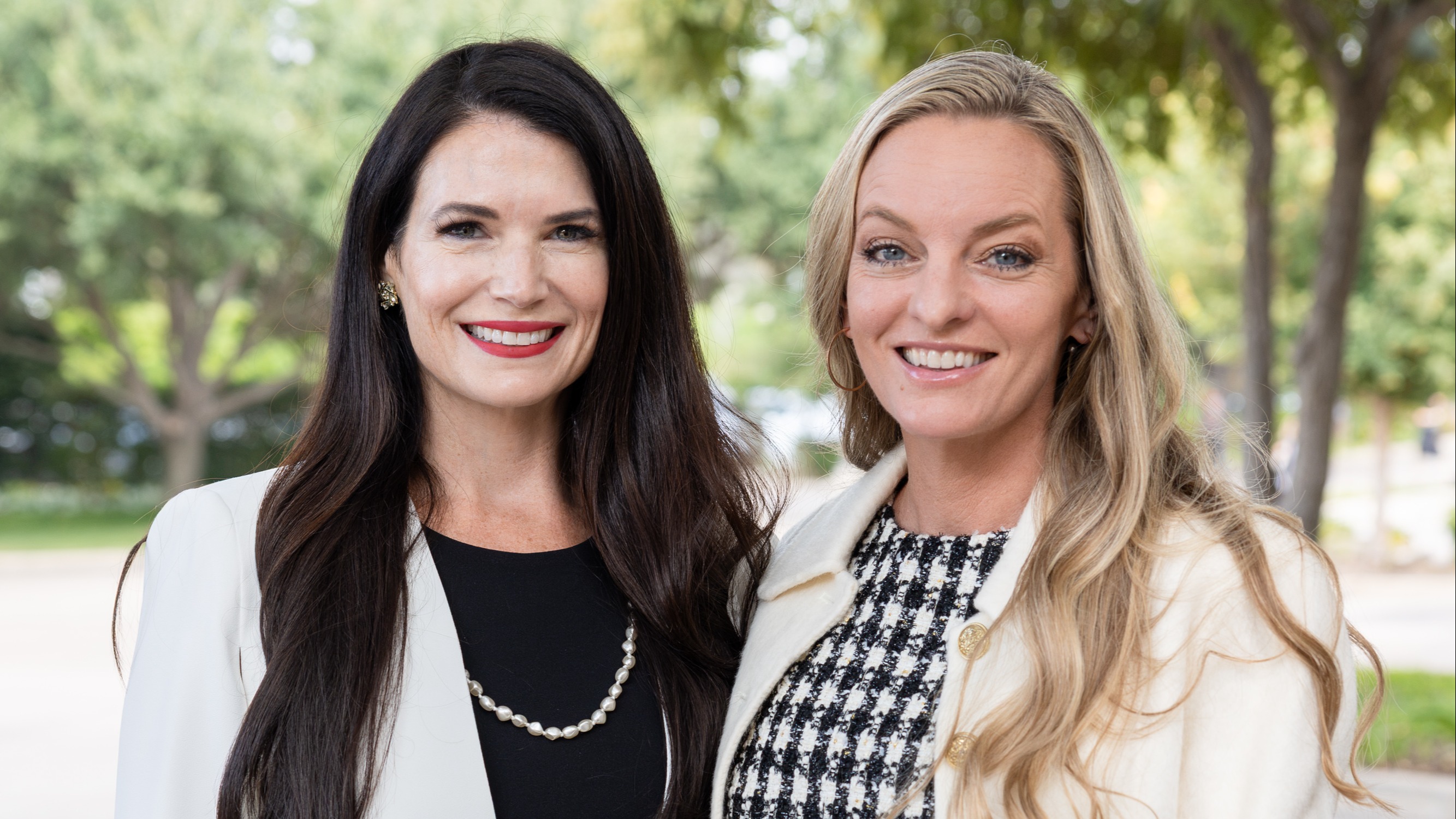 2027 Friends of BrainHealth Co-Chairs Katie Doherty and Laine DiStefano, pictured outdoors in sunlight with a background of trees.