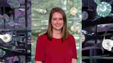 Julie Carter Heckmann Hero with colorful glass sculpture background. Assistant Director of Development.