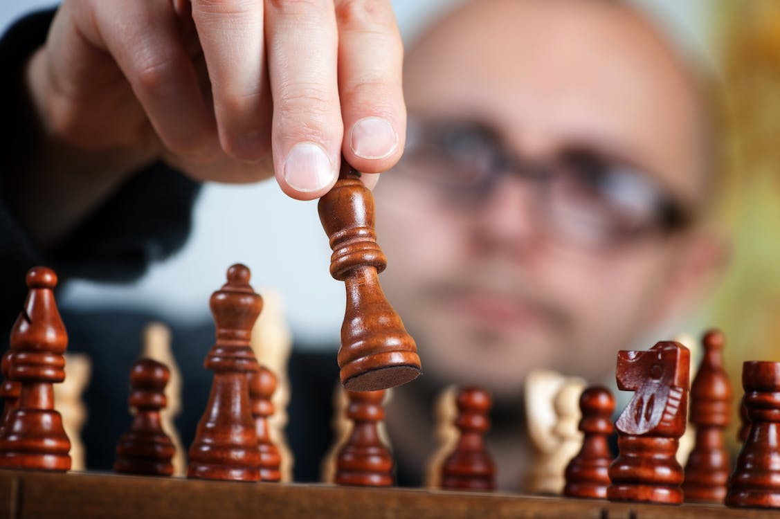 A man with glasses playing chess