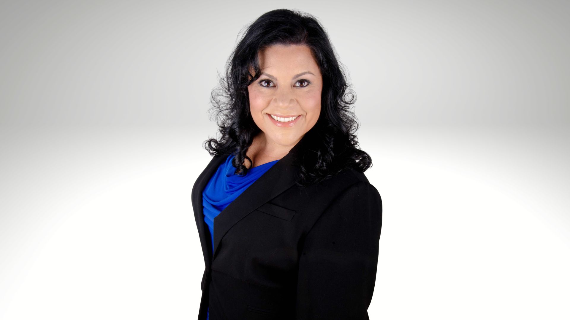 Headshot of Olivia Guerra in a black jacket against a solid white background.