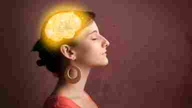 A woman with closed eyes and a glowing golden brain illustration overlaid on her head, symbolizing mindfulness or mental clarity.