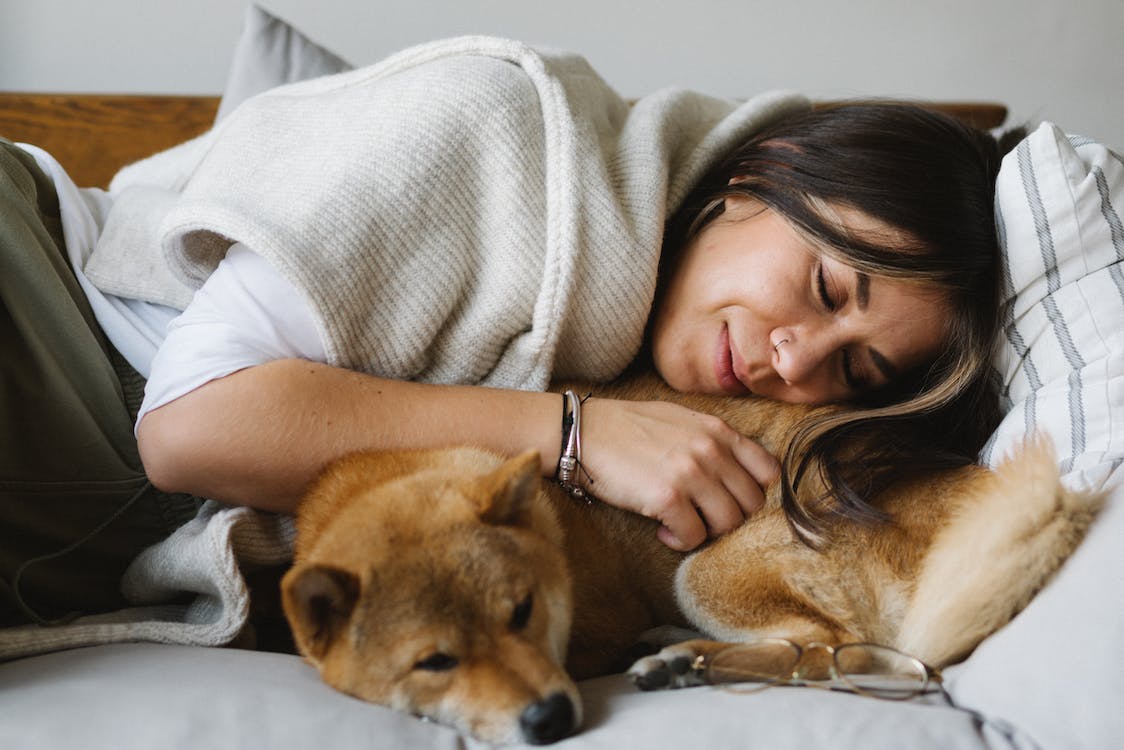 A women taking a nap with her dog