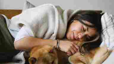 A women taking a nap with her dog