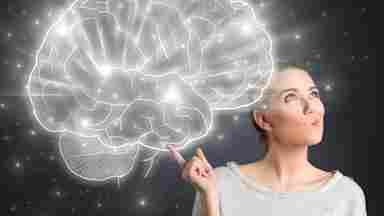A woman is pointing to an illustration of a brain while looking off to the side.
