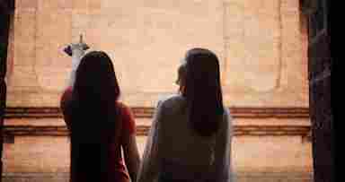 Two young people joyfully explore an ancient temple for the first time.