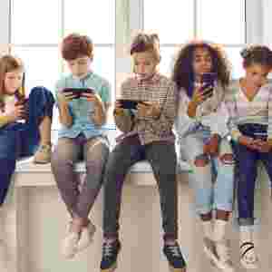 Diverse group of children playing on smartphones, reading, on social networks
