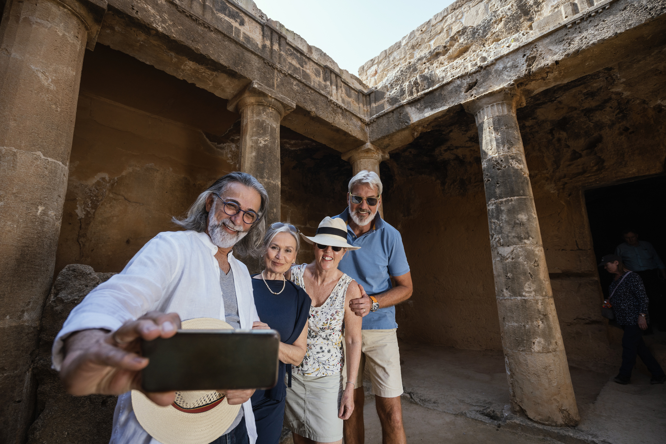 Mature tourist friends visiting tombs of the kings necropolis on Paphos, Cyprus.