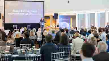 Eti Ben Simon, PhD, presents a lunchtime talk during BrainHealth Week 2026 to a crowd of scientists, students and community members in the modern-looking atrium of the Brain Performance Institute in Dallas, Texas.