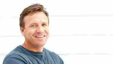 Adult male with his arms folded, smiling and looking at the camera.