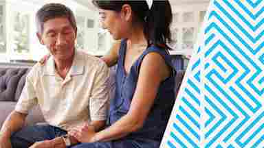 A young adult showing compassion by supporting and reassuring her father at home.