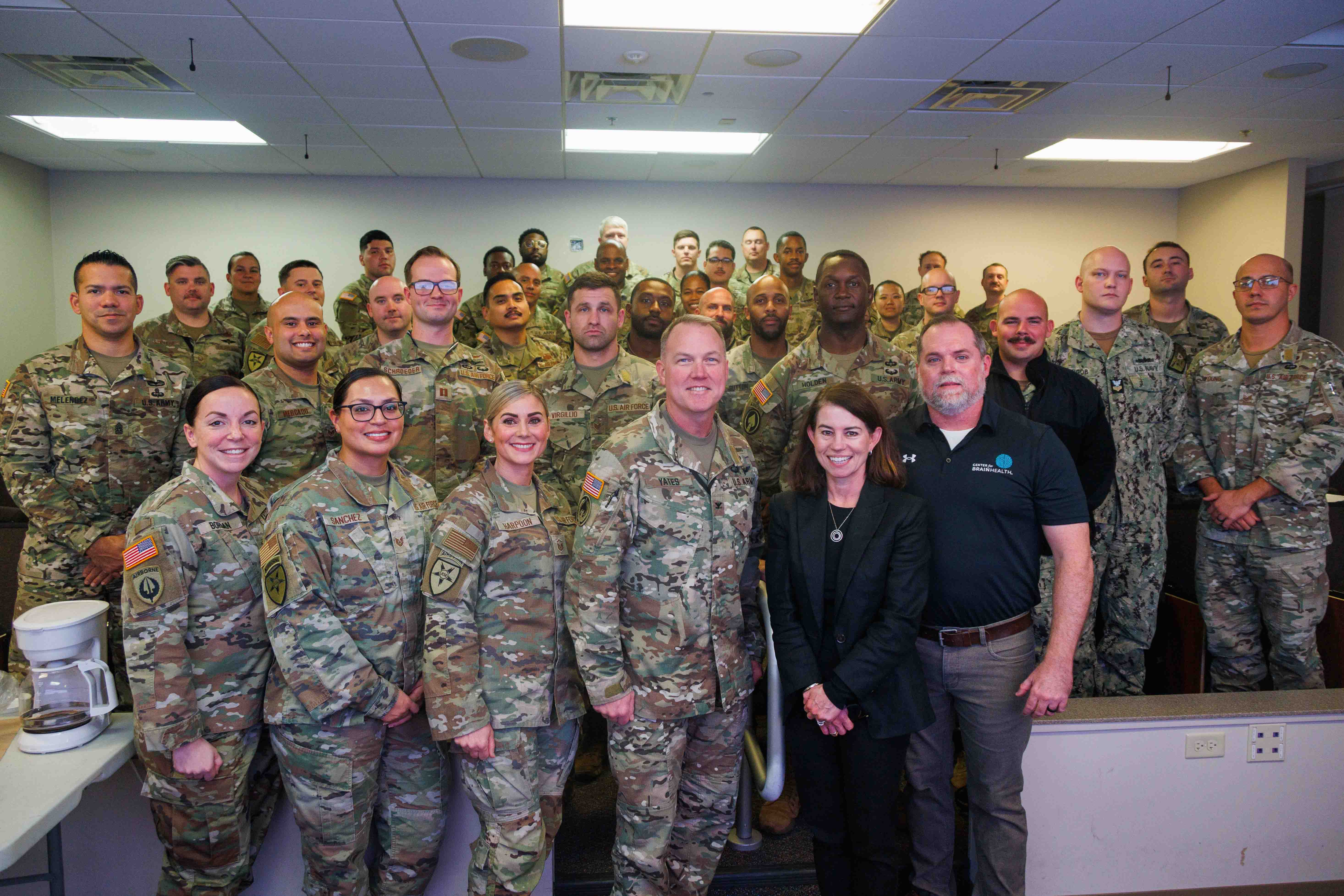 Center for BrainHealth's Jennifer Zientz and Thad King stand with service members participating in Optimal BrainHealth for Warfighters, following a SMART seminar with the Joint Communications Support Element (JCSE) at MacDill AFB, FL. The JCSE is a joint command (Army, Navy, Airforce and Marines).