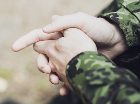 The folded hands of a military man.