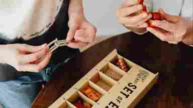 Two people solving a set of puzzles. Overall picture has a warm hue.