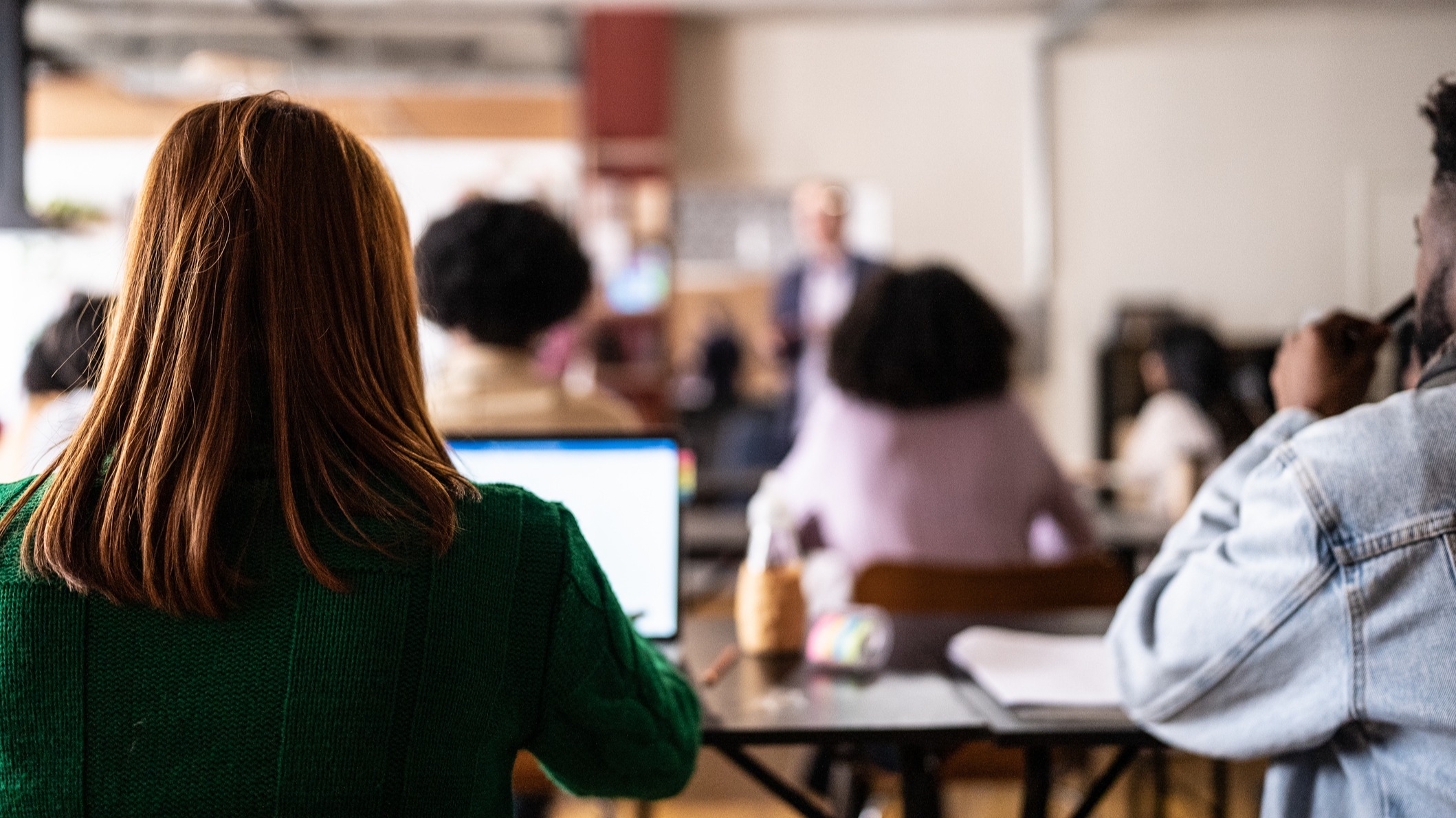 Students take notes during a lecture in a high school or college classroom. 