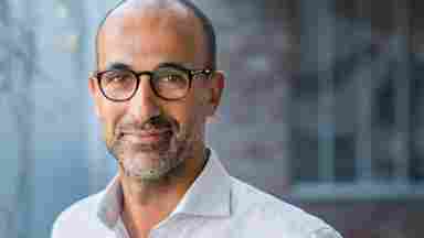 An older man is smiling into the camera.