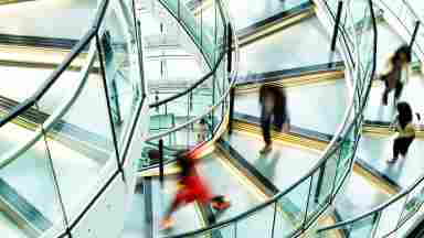 Motion blur of people on a contemporary spiral staircase.