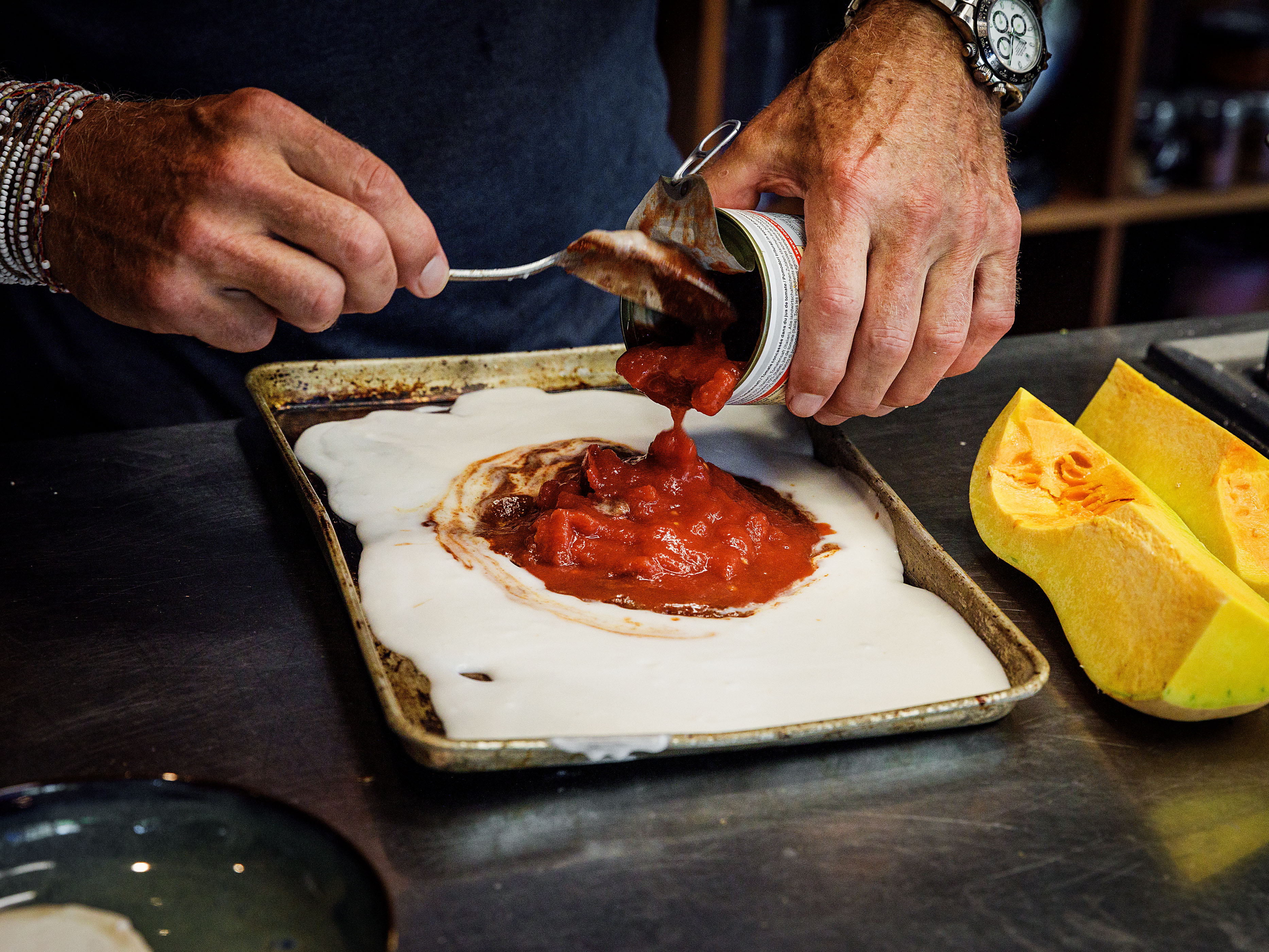 Schritt 1: Currypaste, Kokosmilch, Butternusskürbis, Tomaten und Kichererbsen auf einem Backblech vermengen