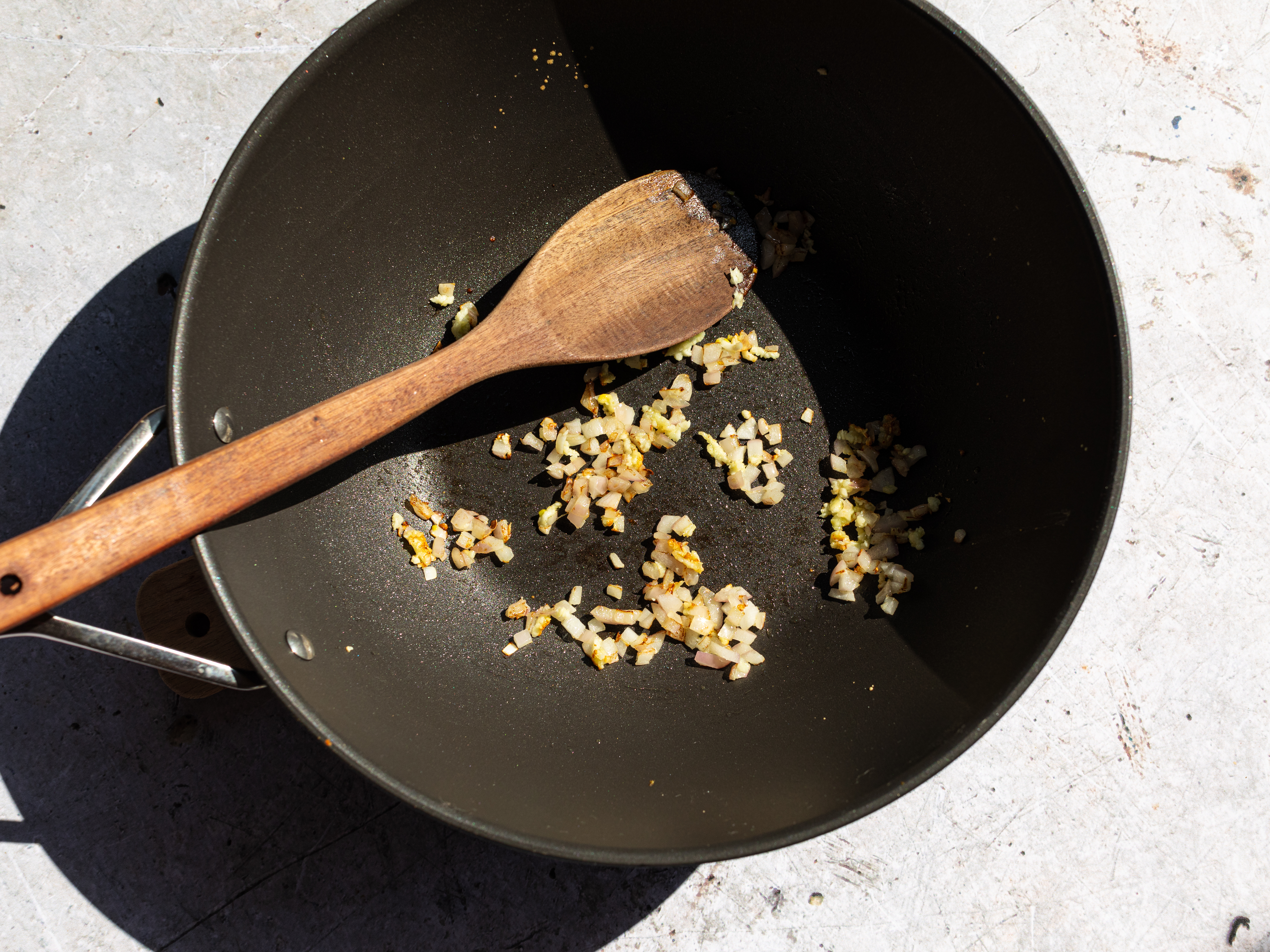 Schritt 2: In einer Pfanne das Olivenöl erhitzen und die gehackte Zwiebel und Knoblauch darin glasig anbraten