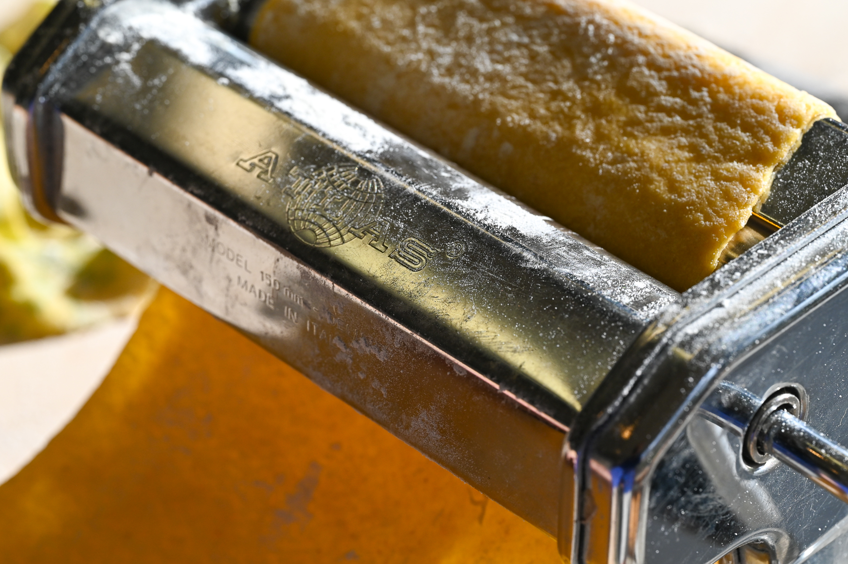 Schritt 3: Die einzelnen Teigstücke mit der Handfläche auf zirka einen halben Zentimeter flach drücken und in der Pastamaschine zu langen Teigblättern ausrollen