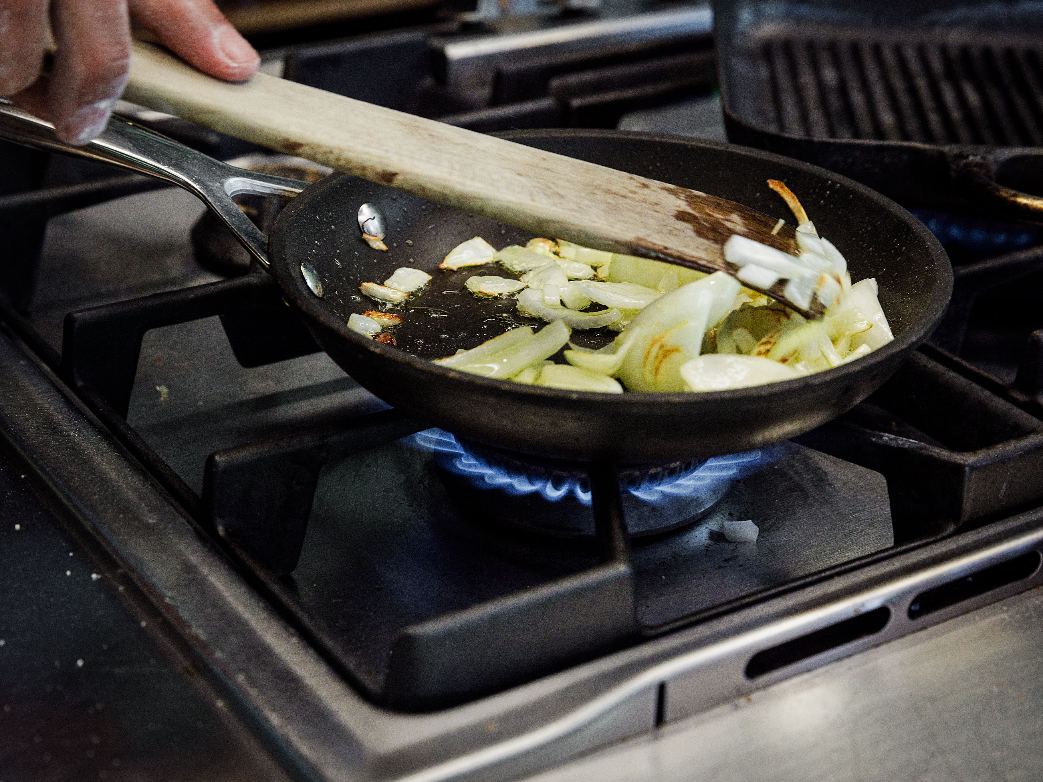 Schritt 2: Etwas Olivenöl in einer Pfanne bei starker Hitze erhitzen und die Zwiebeln darin unter gelegentlichem Rühren zirka 5 Minuten goldbraun braten