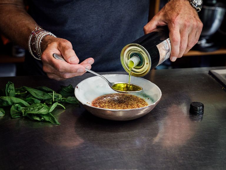 Schritt 3: Olivenöl, Rotweinessig und Senf miteinander verrühren, dann die Hälfte der Basilikumblätter zerkleinern und unter das Dressing rühren.