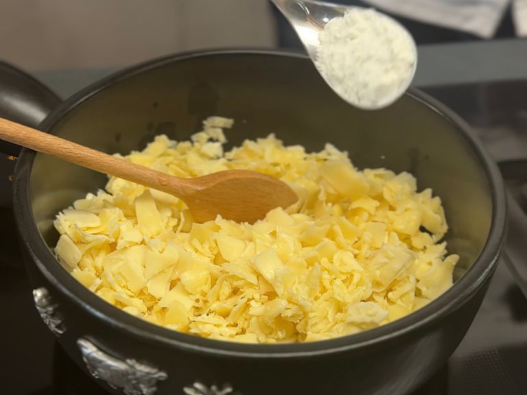 Step 4: Stärke zum Käse in den Topf geben Step 4: Stärke zum Käse in den Topf geben