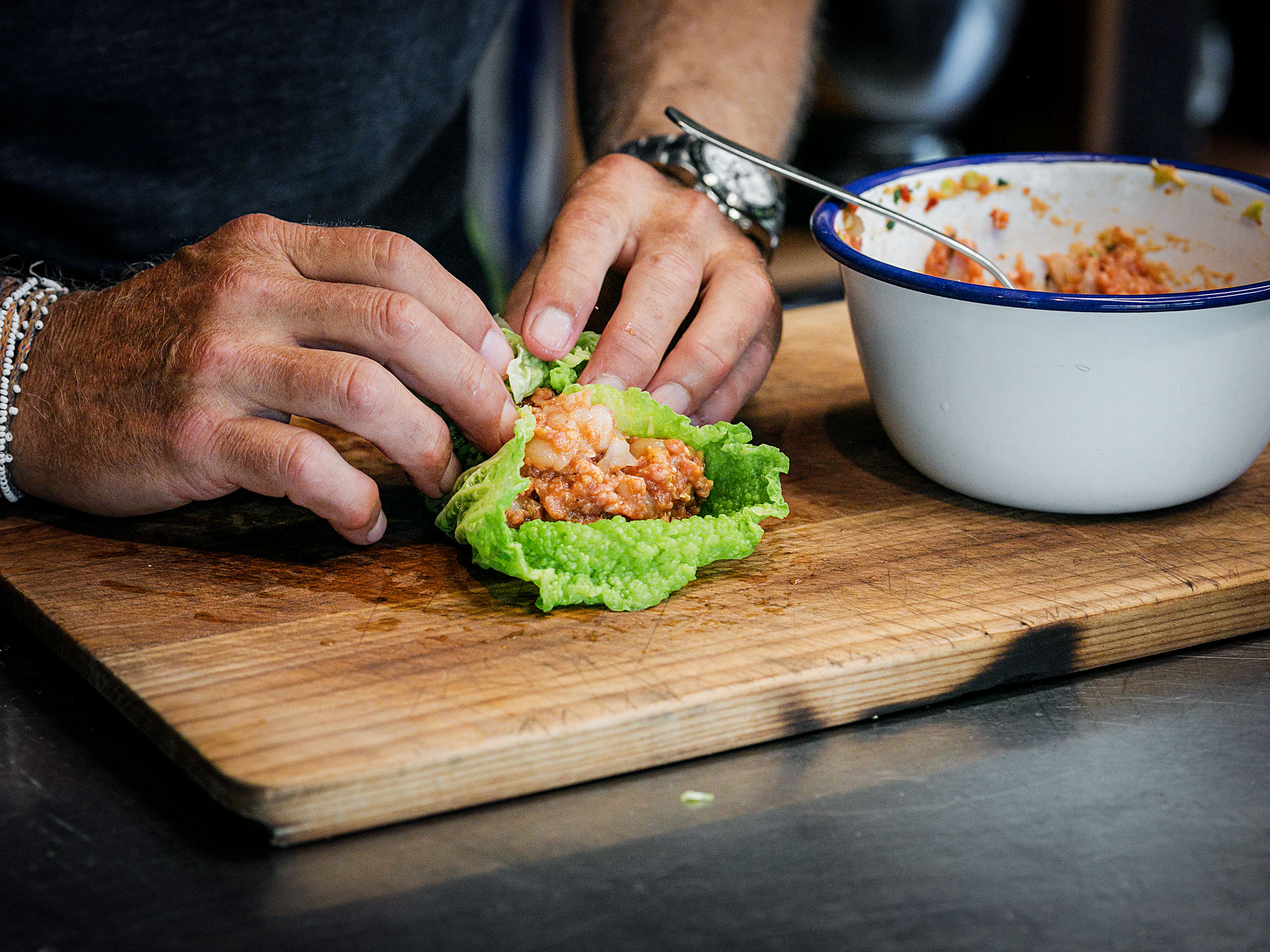 Schritt 3:  Zwei Esslöffel der Füllung in die Mitte der Kohlblätter geben, die Seiten nach innen ziehen und die Kohlblätter einrollen, bis schöne, geschlossene Bündel entstehen