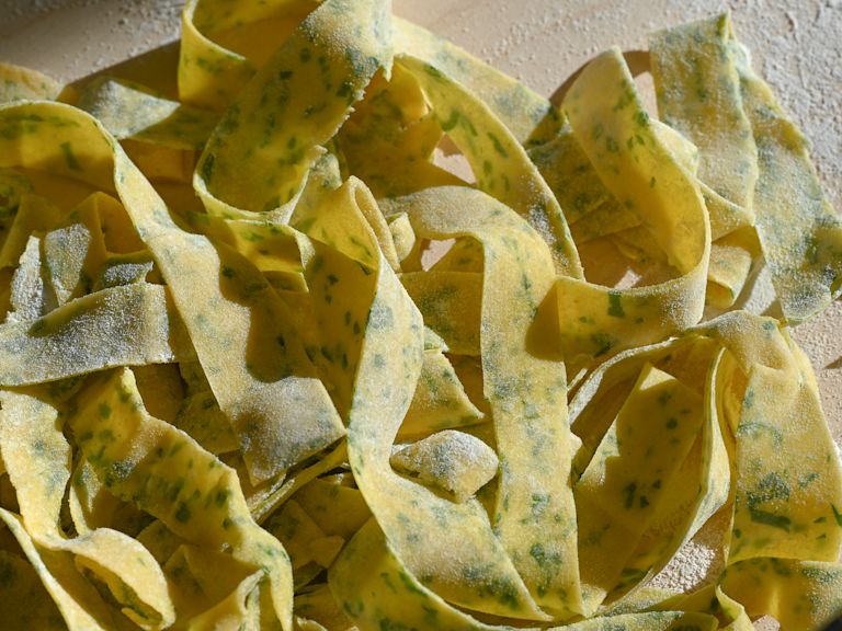 Schritt 4: Die fertigen Teigblätter zusammenrollen und von Hand mit einem scharfen Messer zu zirka 12 mm breiten Pappardelle schneiden. Schritt 4: Die fertigen Teigblätter zusammenrollen und von Hand mit einem scharfen Messer zu zirka 12 mm breiten Pappardelle schneiden.