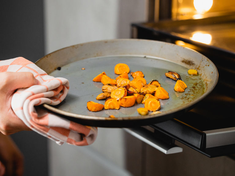 Schritt 1: Die Karottenscheiben, den Knoblauch und den Ingwer auf ein Backblech geben und im Ofen rösten, bis sie weich und leicht gebräunt sind