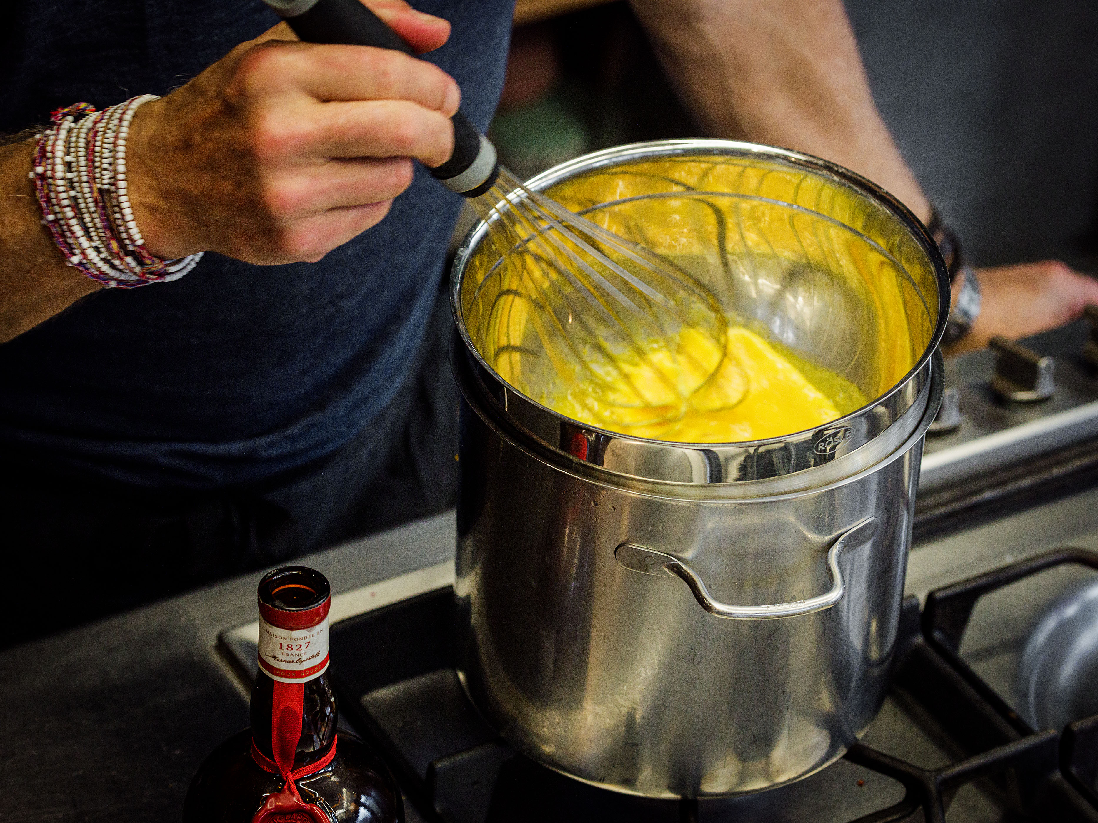 Schritt 3: Die Eigelbe und 20 Milliliter Grand Marnier in einer hitzebeständigen Schüssel über einem Topf mit kochendem Wasser verquirlen, bis sie dick und hell sind