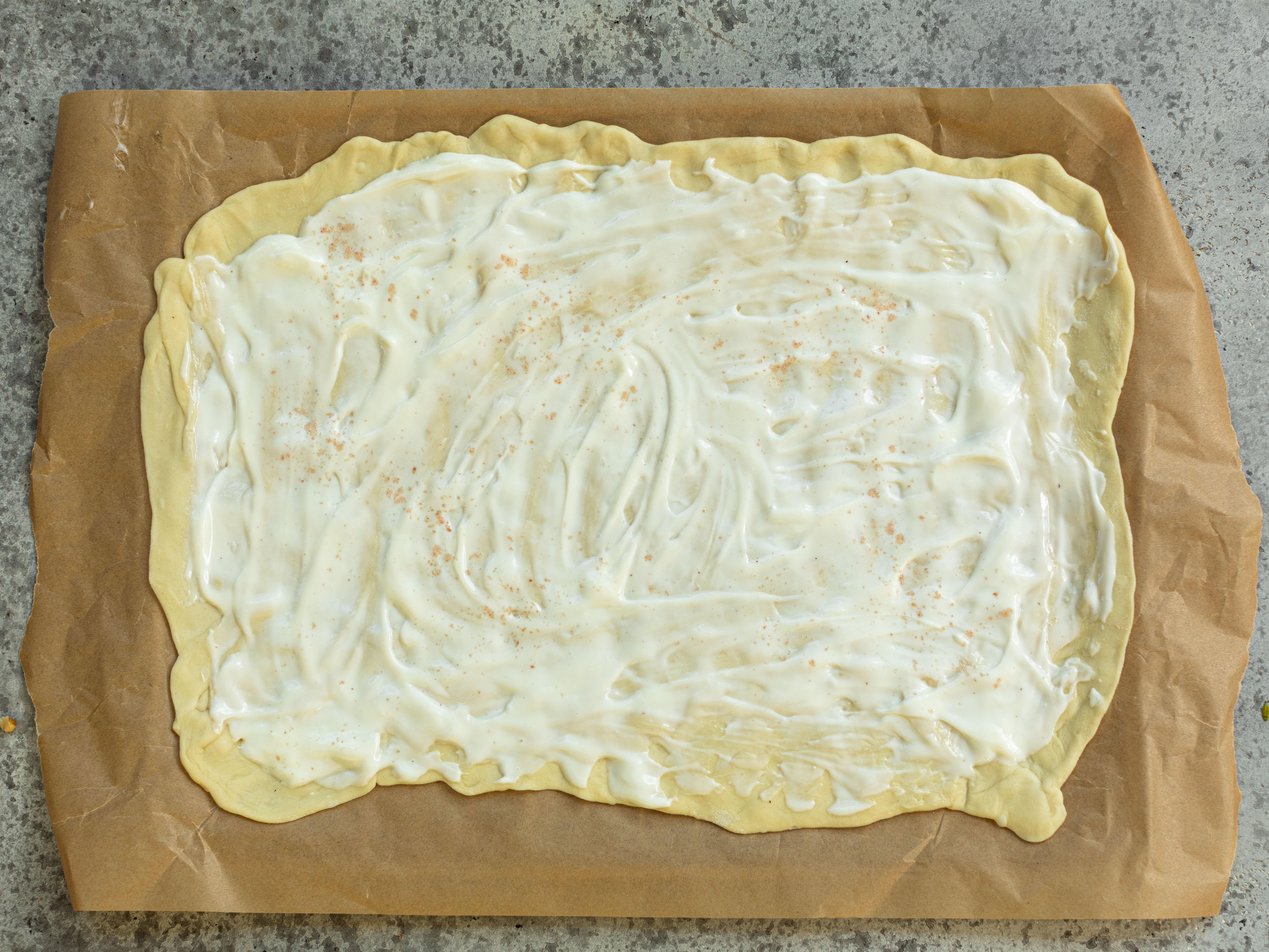 Schritt 4: Jeweils dünn mit der Crème fraîche oder Sauerrahm-Mischung bestreichen, dabei einen kleinen Rand freilassen