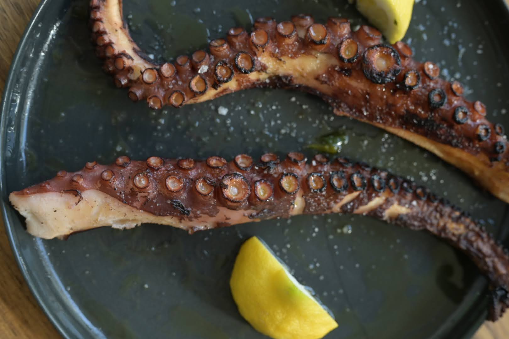 Schritt 4: Den Radicchio etwas auseinander zupfen, Oktopus darauf anrichten und mit den Petersilieblättern und den gehobelten Macadamianüssen bestreuen