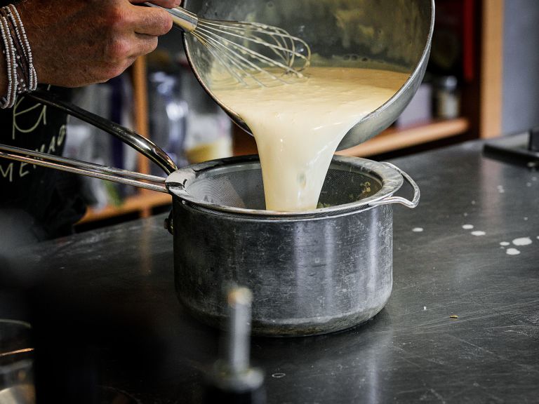 Schritt 4: Den Rahm-Milch-Mix durch ein Sieb geben, zur Eiermasse hinzufügen und bei mittlerer Hitze 5 Minuten unter ständigem Rühren zur Rose kochen