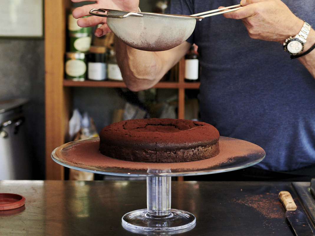 Schritt 6: Glutenfreier Schokoladen-Haselnuss-Kuchen mit Kakaopulver bestreuen.